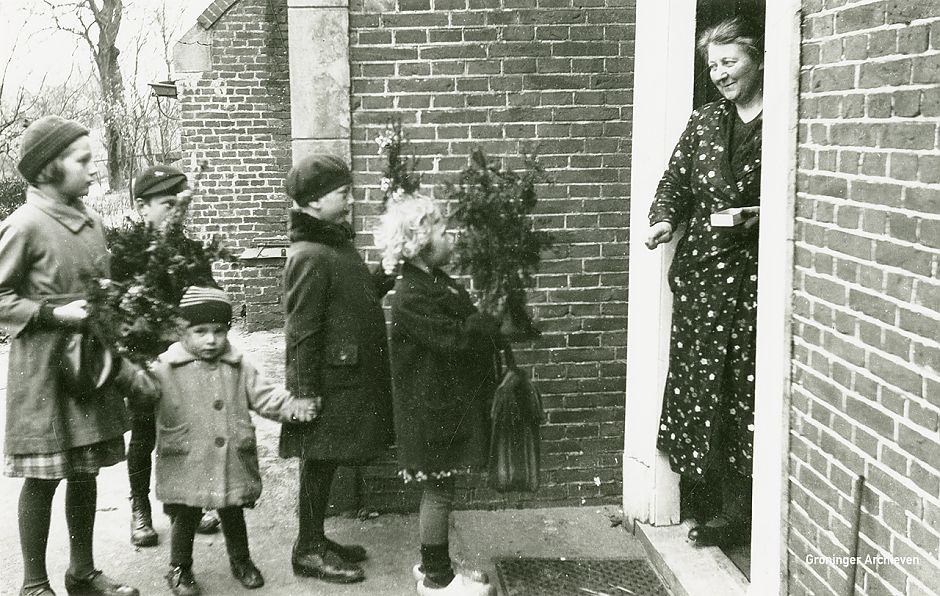 <p>Kinderen staan in Garsthuizen op Goede Vrijdag voor een geopende voordeur met een palmpaastak in de hand, ca. 1930.&nbsp;Foto Mw. E.J. Huizenga-Onnekes, <a href="http://www.beeldbankgroningen.nl/" target="_blank">www.beeldbankgroningen.nl</a></p>
